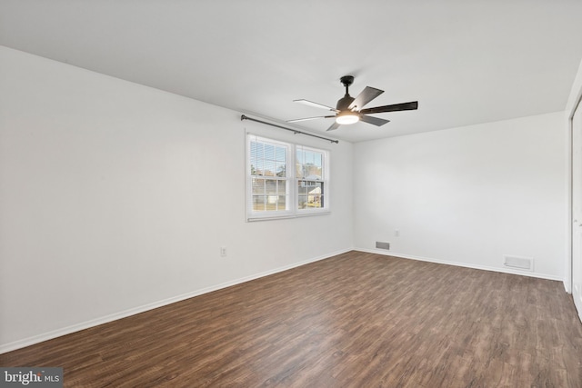 spare room featuring dark hardwood / wood-style flooring and ceiling fan