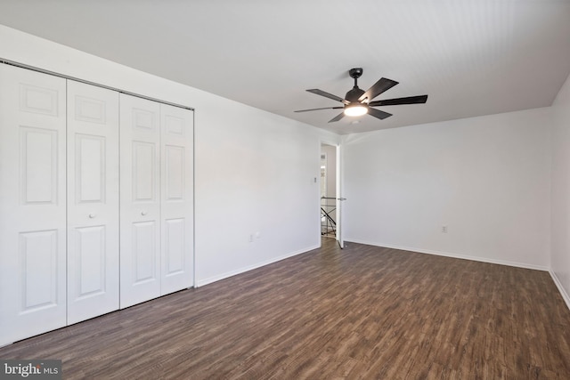 unfurnished bedroom with dark wood-type flooring, ceiling fan, and a closet