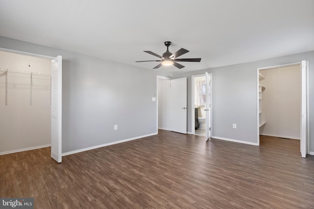 unfurnished bedroom with a closet, a walk in closet, and dark hardwood / wood-style floors