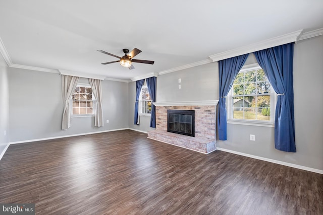 unfurnished living room featuring dark wood-type flooring, ceiling fan, crown molding, and a brick fireplace