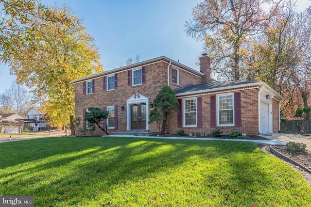 12700 Macduff Dr, Fort Washington, MD 20744 - colonial house with a chimney, brick siding, a front yard, and a garage