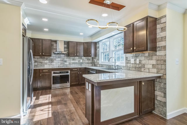 12700 Macduff Dr, Fort Washington, MD 20744 - kitchen featuring stainless steel appliances, wall chimney range hood, a sink, dark wood-type flooring, and a peninsula
