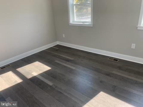 unfurnished room with dark hardwood / wood-style flooring