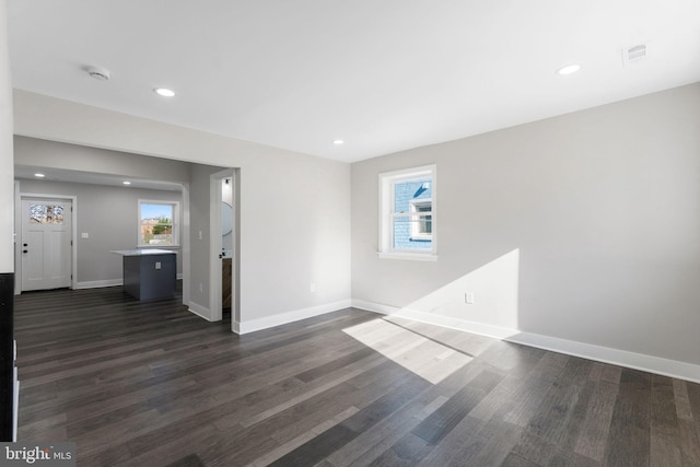 unfurnished room with a healthy amount of sunlight and dark hardwood / wood-style flooring