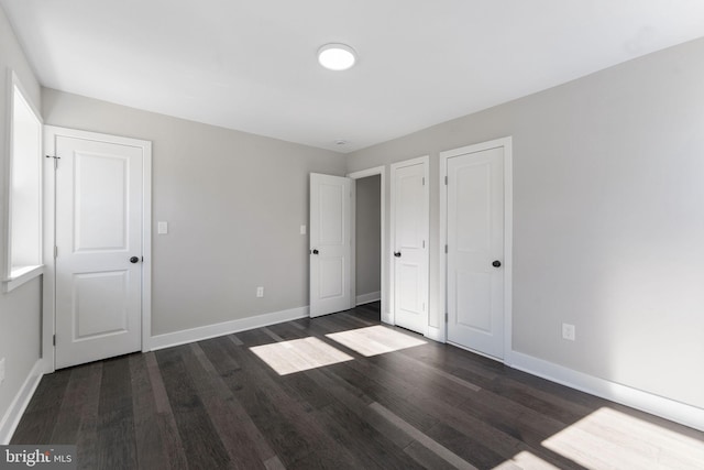 unfurnished bedroom with dark wood-type flooring