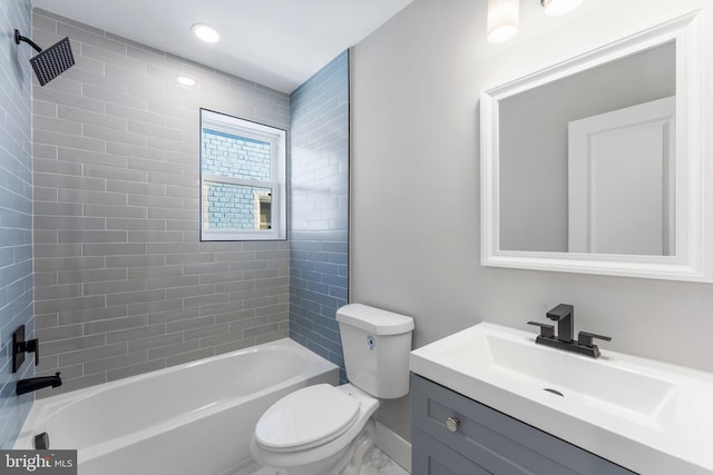 full bathroom featuring vanity, tiled shower / bath, and toilet