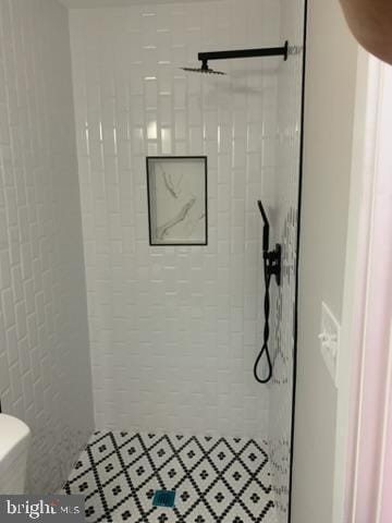 bathroom with toilet and tiled shower