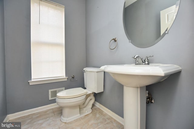 bathroom featuring tile patterned flooring, toilet, and plenty of natural light