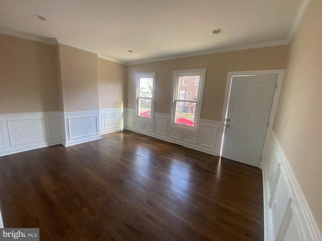 spare room featuring dark wood-type flooring and ornamental molding