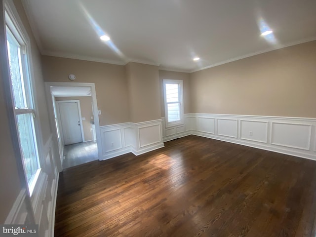 empty room with ornamental molding and dark hardwood / wood-style floors