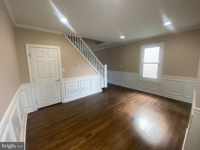 unfurnished room featuring dark wood-type flooring and crown molding