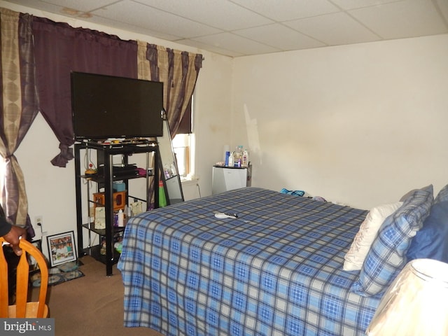 carpeted bedroom with a drop ceiling