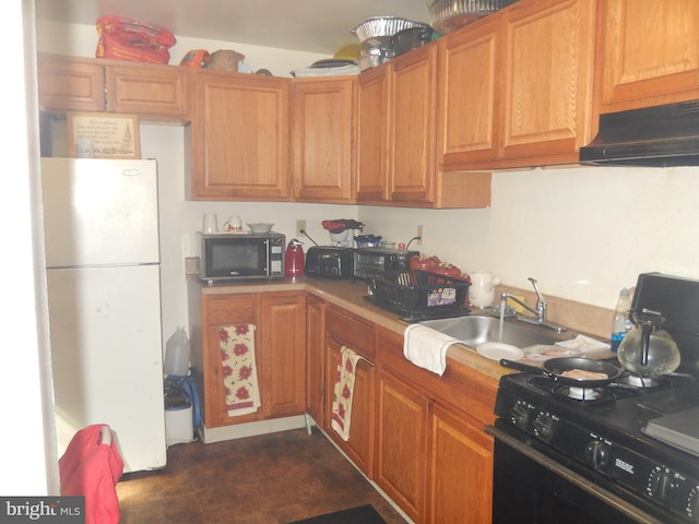 215 Concord Ave, Wilmington, DE 19802 - kitchen with black gas stove, a sink, freestanding refrigerator, under cabinet range hood, and light countertops