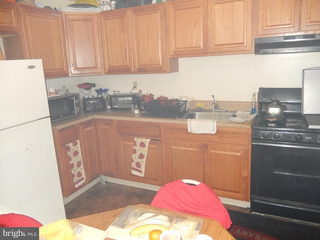 215 Concord Ave, Wilmington, DE 19802 - kitchen with freestanding refrigerator, gas stove, a sink, under cabinet range hood, and light countertops