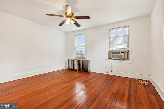 unfurnished room featuring ceiling fan, radiator heating unit, cooling unit, and hardwood / wood-style floors