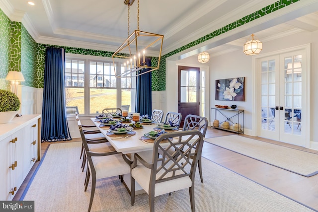 dining area featuring ornamental molding, an inviting chandelier, french doors, and light hardwood / wood-style floors