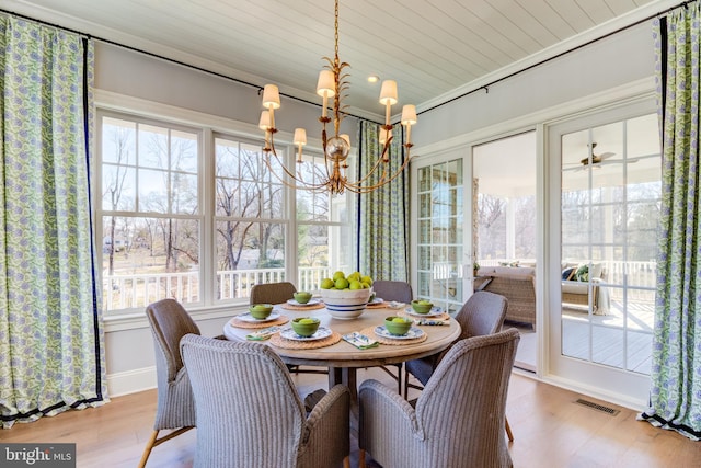 dining space with light wood-type flooring, wood ceiling, and ceiling fan with notable chandelier