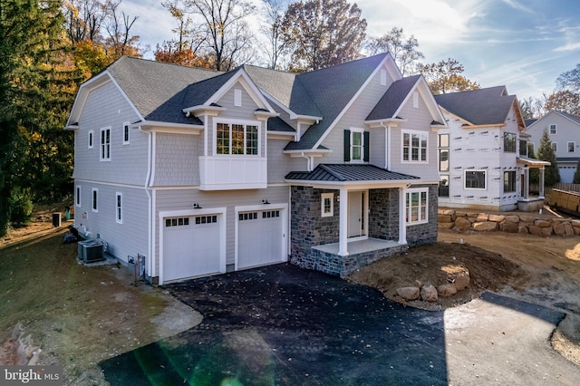 view of front of home with central AC unit and a garage