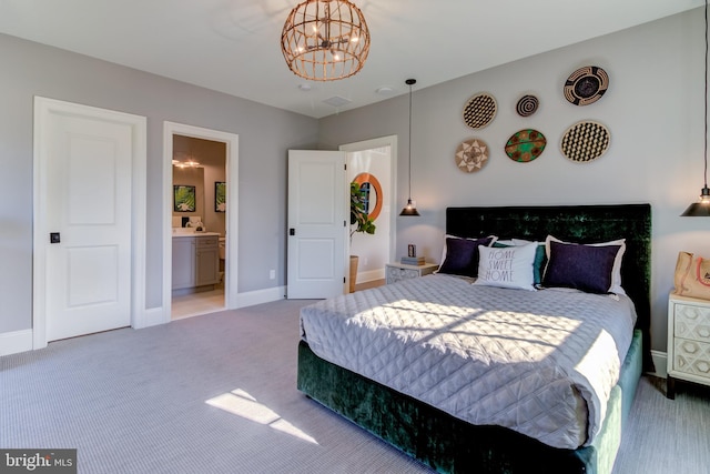 bedroom with connected bathroom, carpet, and a notable chandelier