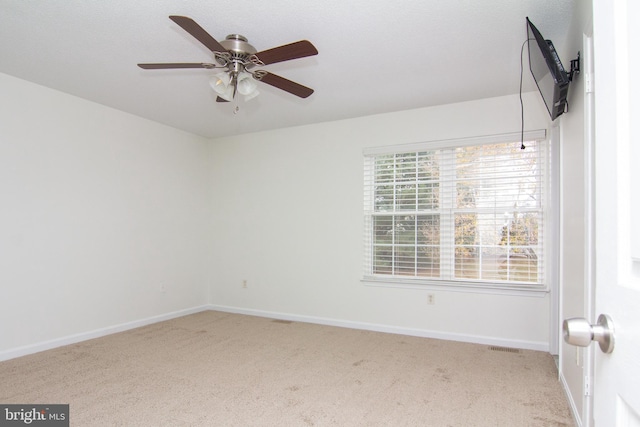 carpeted spare room with ceiling fan