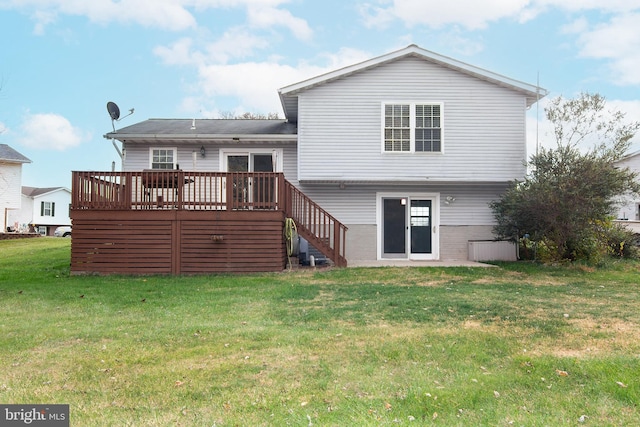 rear view of property with a wooden deck and a yard