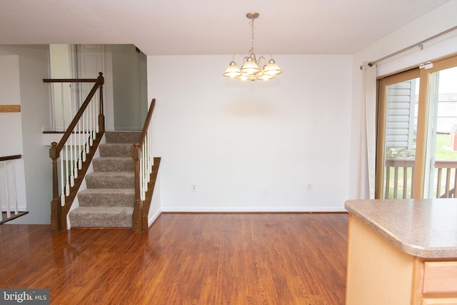 unfurnished dining area with dark hardwood / wood-style floors and a chandelier