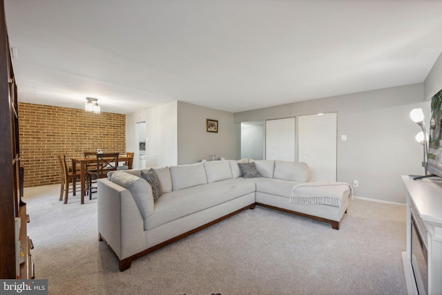 carpeted living room with brick wall