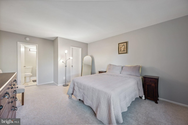 bedroom featuring light carpet and ensuite bathroom