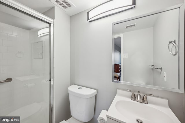 bathroom with vanity, toilet, and a shower with door