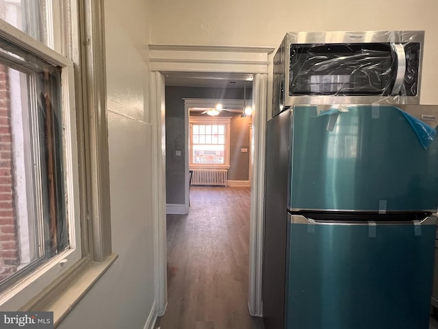 kitchen with stainless steel fridge, radiator heating unit, and dark hardwood / wood-style flooring