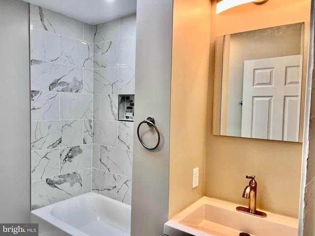 bathroom featuring vanity and tiled shower / bath