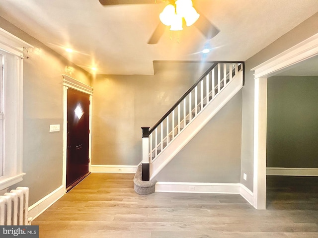 entryway featuring hardwood / wood-style flooring, ceiling fan, and radiator heating unit