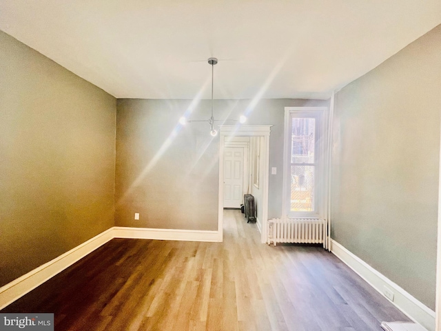 interior space with radiator, ceiling fan, and light hardwood / wood-style flooring