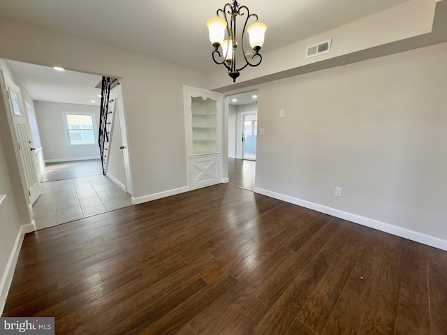 unfurnished dining area with a chandelier and dark hardwood / wood-style floors