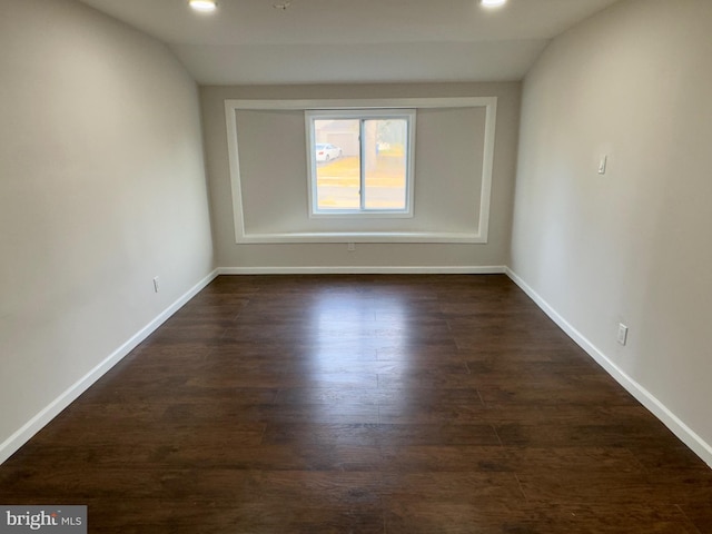 empty room featuring dark hardwood / wood-style floors and lofted ceiling