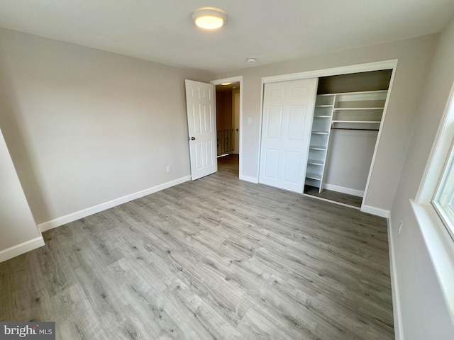 unfurnished bedroom featuring light wood-type flooring and a closet