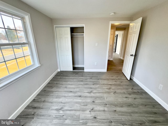 unfurnished bedroom with a closet and light wood-type flooring