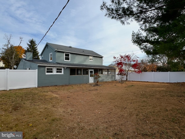 rear view of house featuring a yard