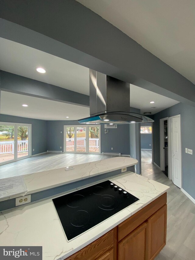 kitchen with light hardwood / wood-style flooring, light stone counters, black electric cooktop, and range hood