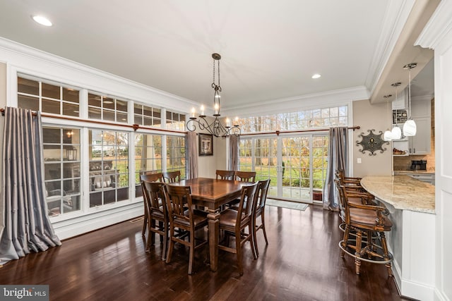 dining area featuring dark hardwood / wood-style flooring, a chandelier, and ornamental molding