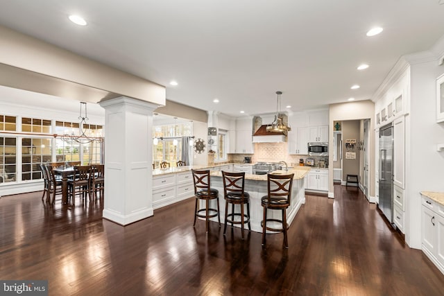 kitchen with tasteful backsplash, hanging light fixtures, and dark hardwood / wood-style floors