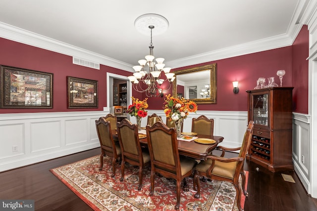 dining area with a chandelier, dark hardwood / wood-style floors, and crown molding