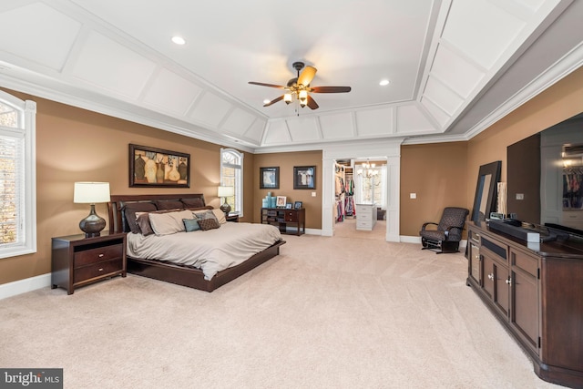 carpeted bedroom with ceiling fan, a closet, a spacious closet, and ornamental molding