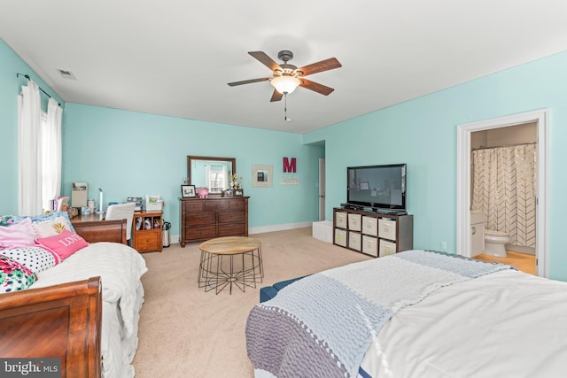 carpeted bedroom with ceiling fan and ensuite bath