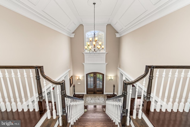 entrance foyer with hardwood / wood-style flooring, french doors, a chandelier, and vaulted ceiling