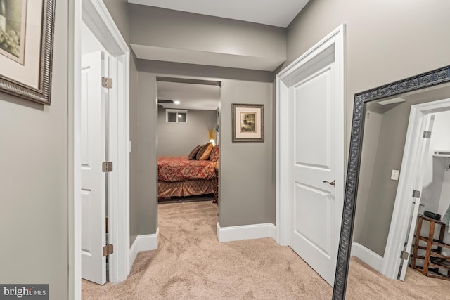 hallway featuring light colored carpet