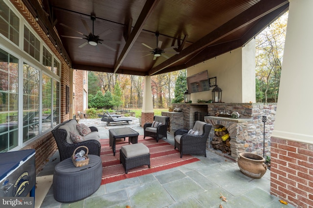 view of patio with an outdoor living space with a fireplace and ceiling fan