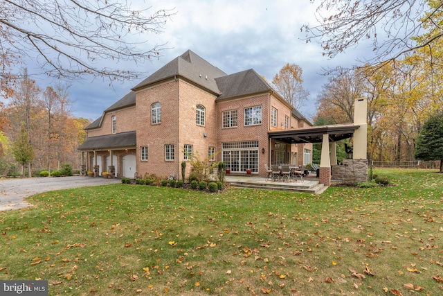 13105 Pendleton Ct, Reisterstown, MD 21136 - back of house with brick siding, an attached garage, asphalt driveway, a chimney, and a patio