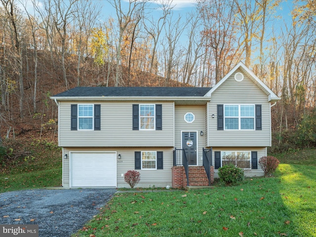 raised ranch with a front yard and a garage