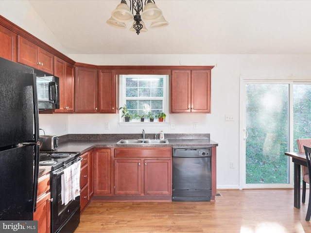 kitchen with black appliances, light hardwood / wood-style floors, lofted ceiling, and sink